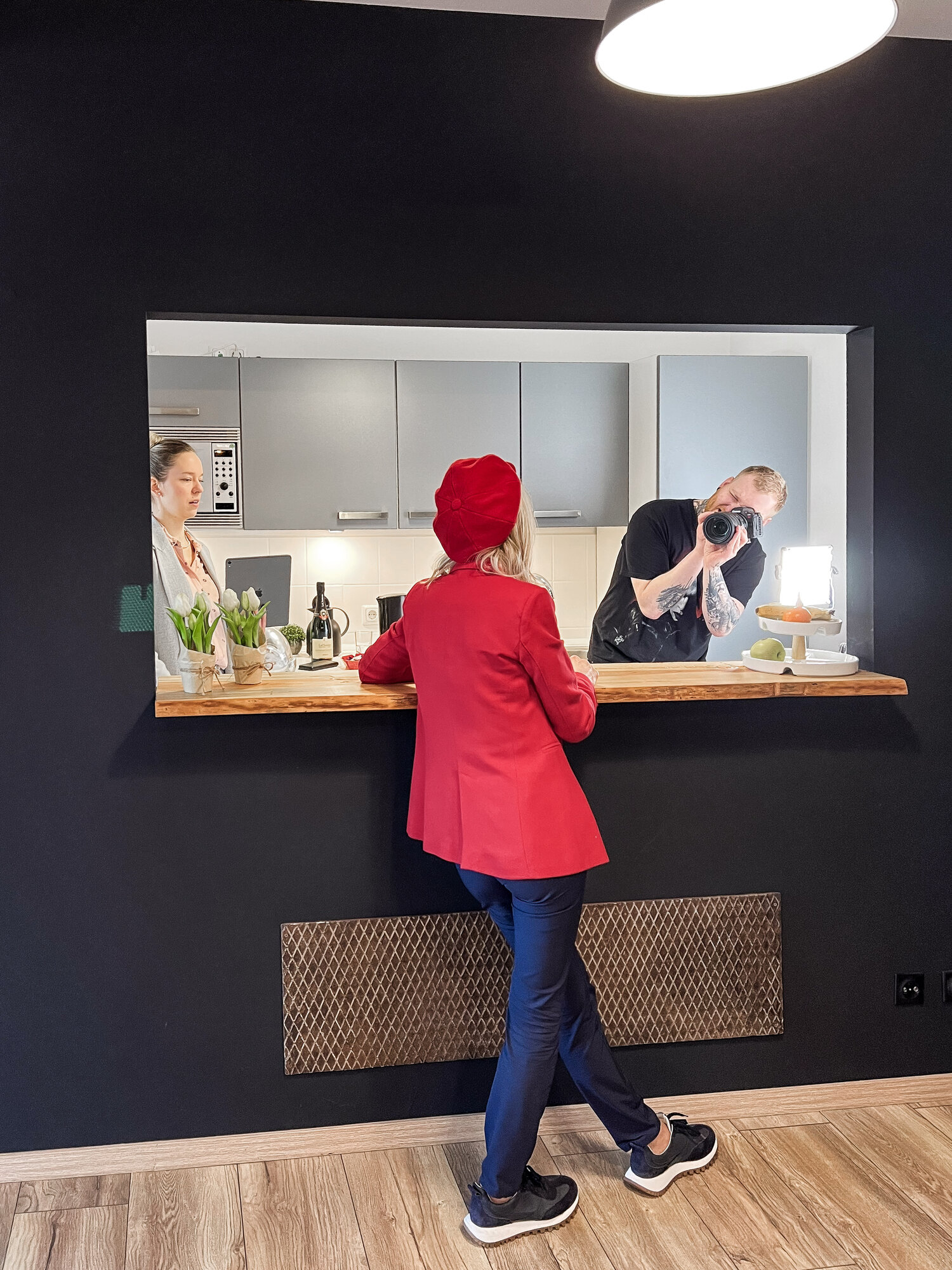 Frau in roter Kleidung steht an einer Bar in einem Making-off Shooting